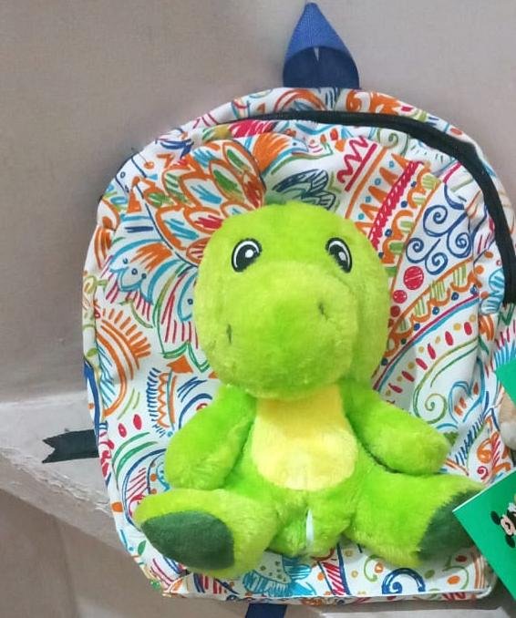 Fabric school bag with attached dinosaur plush